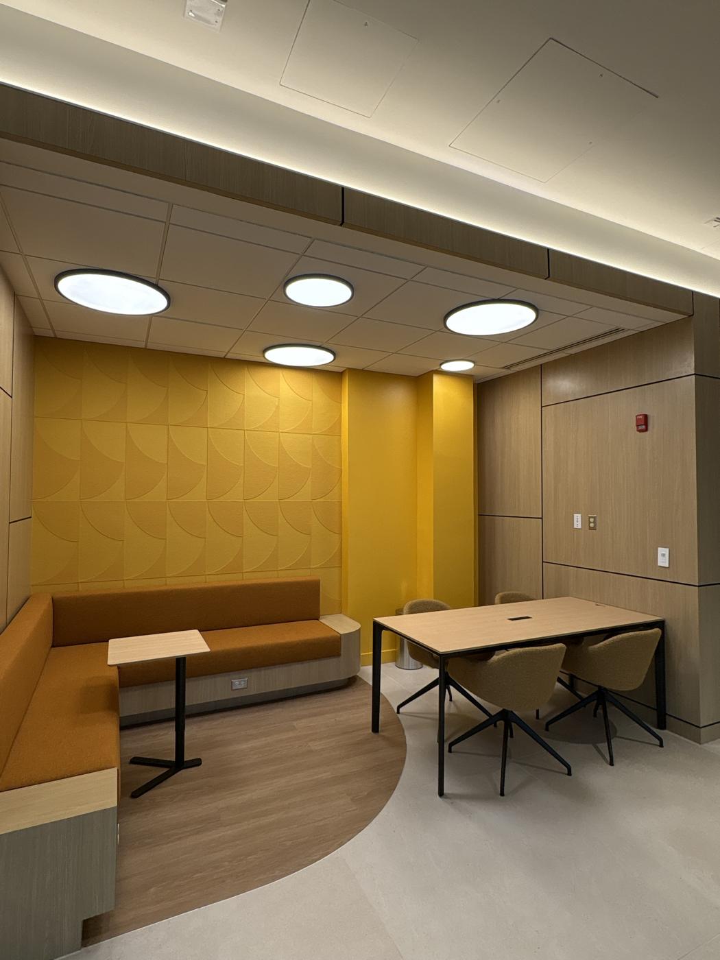 Lounge with acoustical ceiling, wood soffit and yellow accent wall