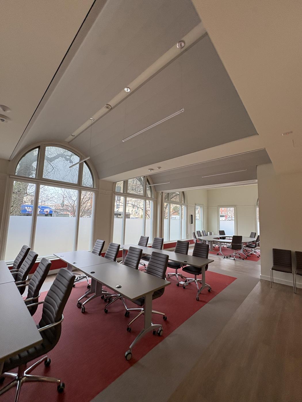 Training room with sloped drywall ceiling under arched windows